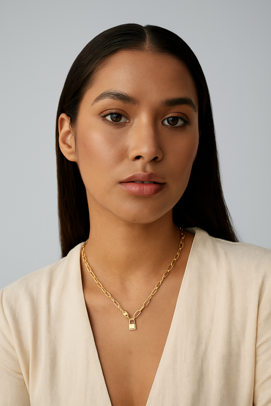 Woman wearing a gold necklace against a plain background